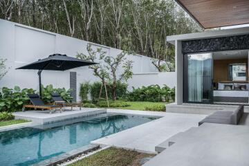 Modern outdoor area with pool, lounge chairs, and adjacent bedroom