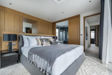 Modern bedroom with wooden panel accent wall, bed with gray and white bedding, and nightstands