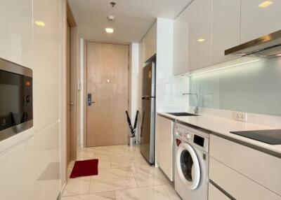 Modern kitchen with white cabinetry, built-in appliances, and light-colored marble flooring