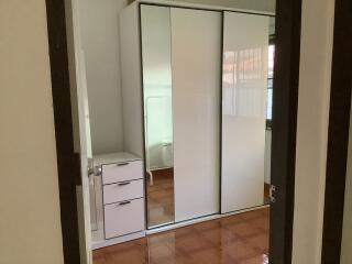 Bedroom with mirrored sliding door wardrobe and wooden floor