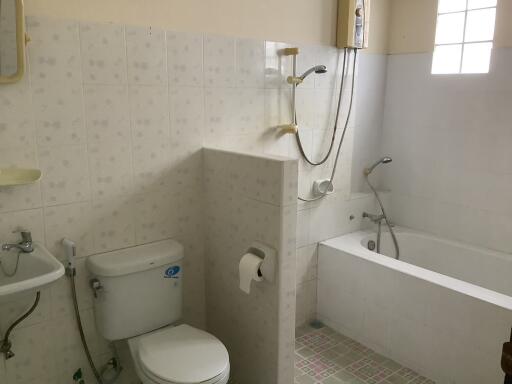 A bathroom with a toilet, bathtub, and shower