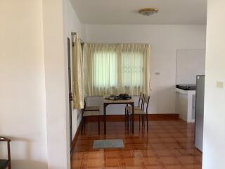 Small dining area with table and chairs next to a window