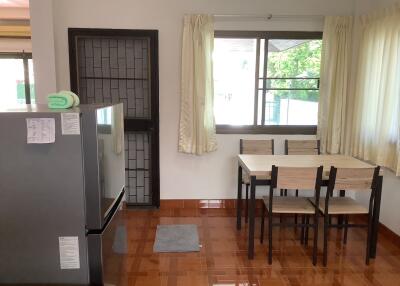 Modern kitchen with large window, dining table, and refrigerator