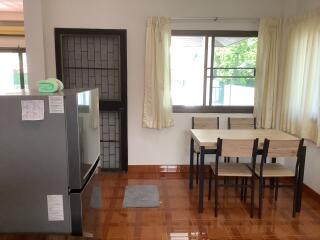 Modern kitchen with large window, dining table, and refrigerator