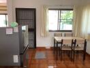 Modern kitchen with large window, dining table, and refrigerator