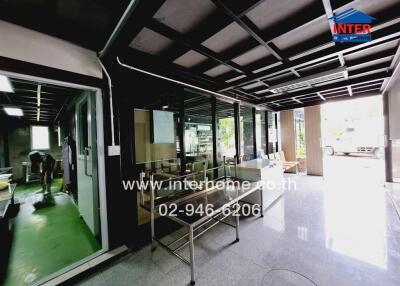 Interior view of a commercial building with glass walls and a work area.