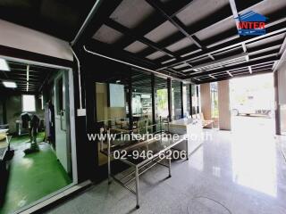 Interior view of a commercial building with glass walls and a work area.