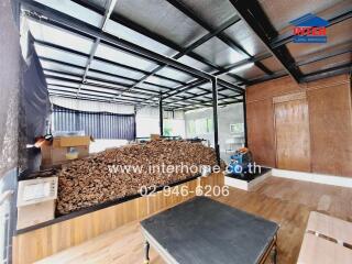 Spacious indoor area with stacked firewood and boxes