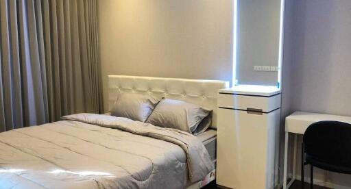 Bedroom with double bed, curtains, and illuminated mirror unit