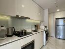 Modern kitchen with white cabinetry, appliances, and washer