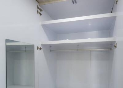 Spacious closet with built-in shelves and desk