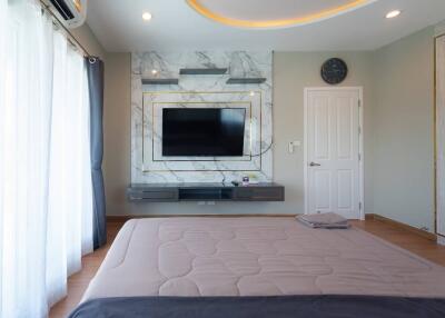 Modern bedroom with wall-mounted TV and minimalist decor