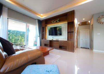 Spacious living room with modern furnishings and large TV
