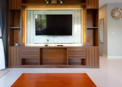 Living room with built-in wooden entertainment center and wall-mounted TV
