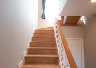 Bright staircase with wooden steps and white railings