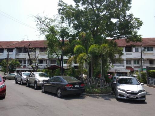 Exterior view of residential buildings with parked cars and trees