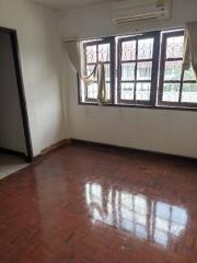 Empty bedroom with wooden flooring and barred windows