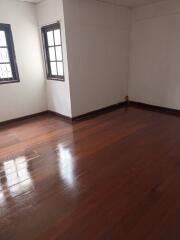 Empty bedroom with wooden floors and windows