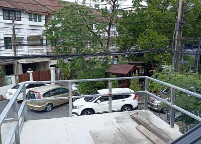 Balcony view with railing and parked cars