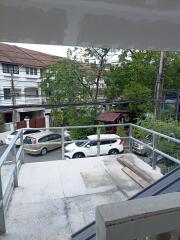 Balcony view with railing and parked cars