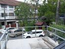 Balcony view with railing and parked cars