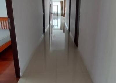 Long corridor with tiled floor and multiple doors