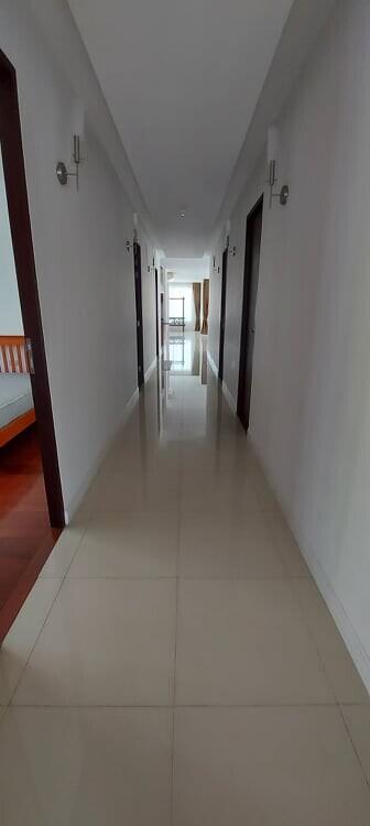 Long corridor with tiled floor and multiple doors