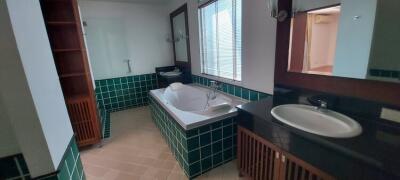 Bathroom with bathtub, sink, and large mirror