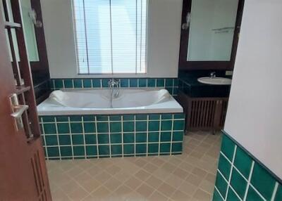 Modern bathroom with window, bathtub, and tiled walls