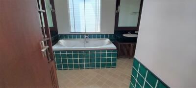 Modern bathroom with window, bathtub, and tiled walls