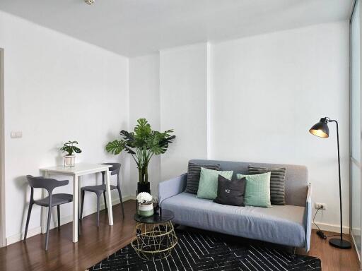 Modern living room with gray sofa and dining area