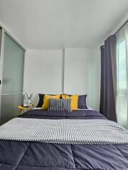 A neatly made bed with colorful pillows in a bright bedroom