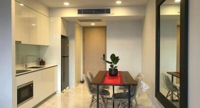 Modern kitchen and dining area with sleek white cabinetry and small dining table