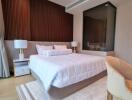 Modern bedroom with double bed, bedside tables with lamps, and a seating area