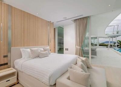 Modern bedroom with a large bed, wooden paneling, and a view of the pool