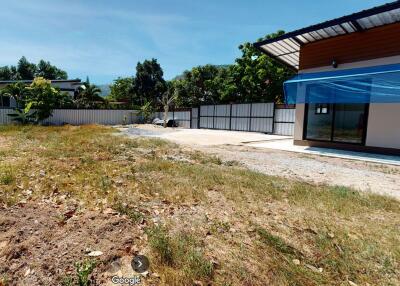 Exterior view of a residential property with partial backyard and building structure