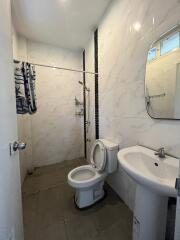 Modern bathroom with toilet, sink, and shower area