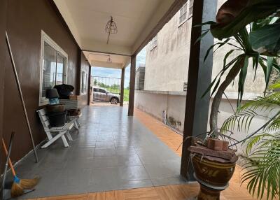 Covered patio area with tiled flooring and plants