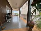 Covered patio area with tiled flooring and plants