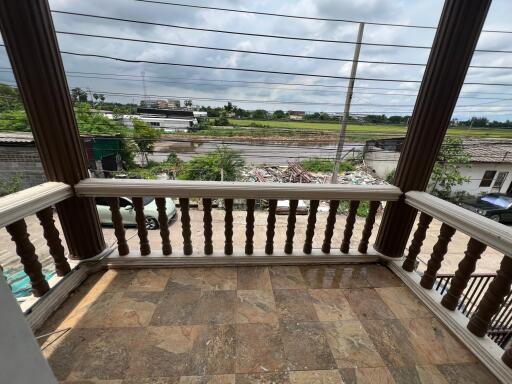 Balcony view with tiled flooring and surrounding neighborhood