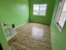 Small bedroom with green walls and wooden floor