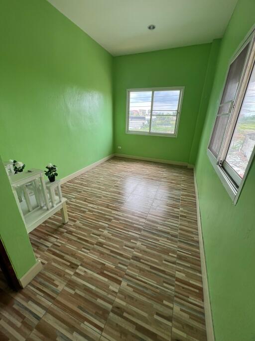 Small bedroom with green walls and wooden floor