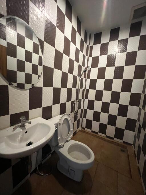 Bathroom with checkerboard wall tiles and basic fixtures