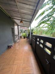 Covered patio area with tiled floor and potted plants