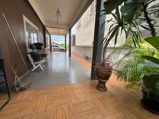 Covered outdoor patio with plants and seating area