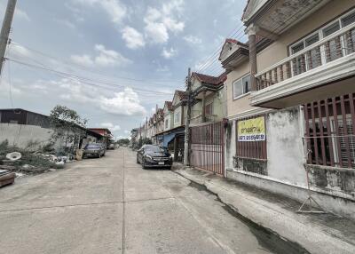 Street view of residential buildings with parked cars