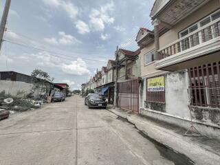 Street view of residential buildings with parked cars