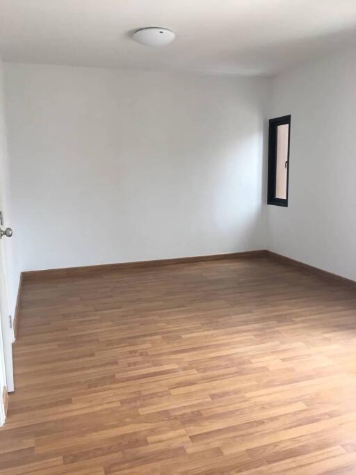 empty bedroom with wooden floor and a window