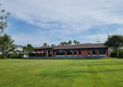 A spacious property with a large lawn and a modern one-story building