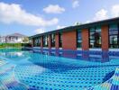 Outdoor swimming pool with clear blue water next to a modern building